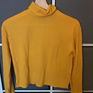 Polotröja  - En gul ribbad polotröja, lite genomskinlig strl: xs pris: 40kr+frakt