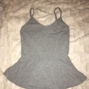  - Grått peplum linne från Bikbok. Passar både XS och S. Passar till mycket och är väldigt fint nu på sommaren. Knappt använt och alltså i väldigt fint skick! :)
