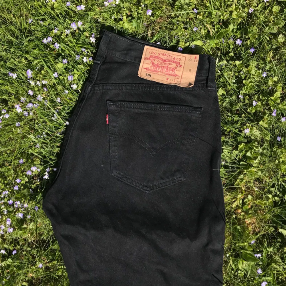 Ett par svarta Levis 501 jeans som är nästan helt oanvända. Enda problemet är att knappen högst upp i midjan saknas, det är möjligt att få fixat. Midjans bredd är ungefär 39cm och innerbenets längd är 75cm Spårad frakt = 58kr. Jeans & Byxor.