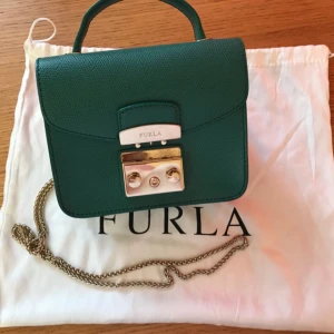  - Kvinnors "Metropolis" crosshatch texturerad läder korsväska vässas med högglans guldton-hårdvara från lyxig italiensk etikett Furla. Handväskan är tillverkad av högkvalitativt texturerat