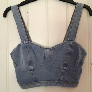  - En helt oanvänd crop top från Topshop i storlek 36. Tyget är mjukt och töjbart i denim liknande färg. Fraktkostnad tillkommer.