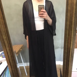  - Lång genomskinlig kaftan med snitt på sidor. Passar en S/M.  