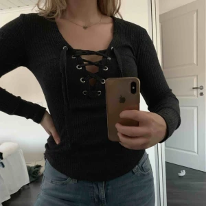  - Grå, ribbad tröja med snörning. Passar till allt. Är i ett bra skick trots väl använd:)