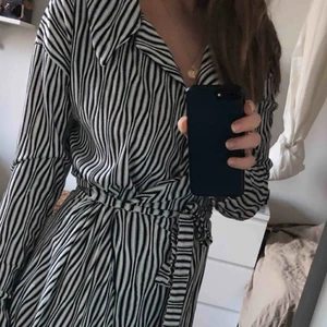  - Superskön mönstrad klänning. Den går till strax över knäna, har ett bälte och en liten elastisk öppning på ryggen. 