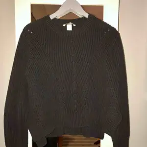 Stickad tröja från H&M, normal i passform. Färgen är mörkgrå/svart. Ser ny och fin ut! Fri frakt!