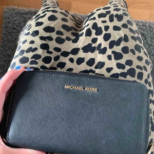  - En as snygg plånbok från Michael kors aldrig har använts då jag har två fast i olika färger. Älskar den, man får plats med pass, mobil (om du har en mindre model), pengar, kort osv. Köpt för 1095kr, pris kan diskuteras