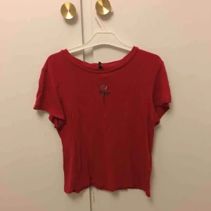  - Röd t-shirt från hm. Broderad ros på. Frakt på 59kr tillkommer. 
