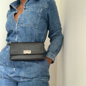 Axelremsväska  - Svart väska med justerbar axelrem. Man kan bära den runt midjan, över ena axeln och även cross-over. Den är verkligen inte tung eller klumpig. Den har flera fack på insidan.