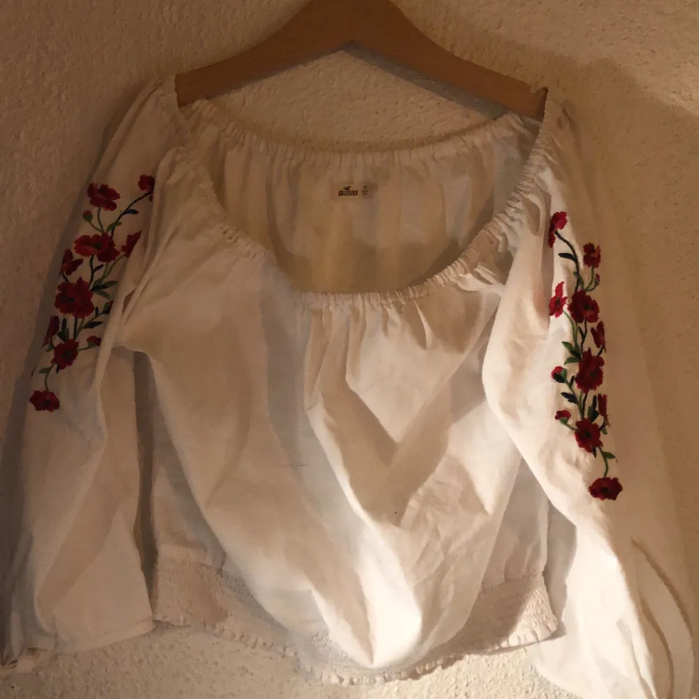 En off-shoulder tröja med rosor sydda på armen. Den har knytningar längst ner på ärmen (skicka om du vill ha bilder:) . Tröjor & Koftor.