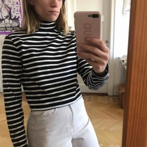  - Svart och vitrandig polotröja. Lite kortare i modellen. Jättefin. Köparen står för frakt men kan även mötas upp (i stockholm)