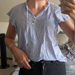 Randig blus - En jättesöt blus från H&M som aldrig kommit till användning. Det går att bära den på två olika sätt som syns på bilderna beroende på om man väljer att knyta snörena! Pris:40kr+49kr frakt