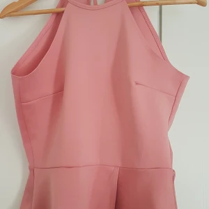 Rosa linne i stl M - Rosa linne i stretchigt tyg, storleken är i M men passar nog som L också. Går att knyta i nacken. Har endast blivit använd några gånger och är i gott skick 