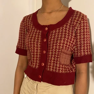 Cardigan - Superfin röd cardigan med ”houndstooth” mönster från Lindex köpt på Myrorna. Inga defekter. (Kan skicka närmare bilder om så önskas). Vid flera intresserade blir det budgivning. Köpare står för frakt 🧶