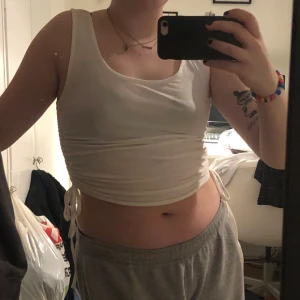 Vitt linne från Nelly - Ett linne med breda axelband och knytning i sidan från Nelly. Frakt 49kr eller mötas upp i Malmö/Lund.