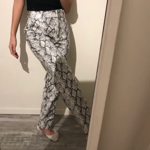 Mönstrade byxor - As coola krokodil/orm mönstrade byxor. Super bekväma byxor för att vara av läder (tror jag), använt sparsamt fåtal gånger !! Köpt på Monki för 399kr, strl 32 ✨✨✨ Köparen står för frakt 🚚 