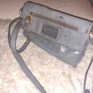  - Handväska Marc by Marc Jacobs.  Sliten på lädret, se bilder. Mer bilder kan skickas. Övrigt fint skick.   