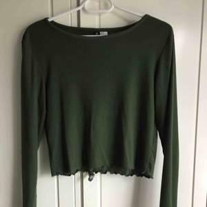 Ribbad mörkgrön tröja med detaljer i ärmar och vid magen. Passar även storlek L.  Köparen står för frakt ;)