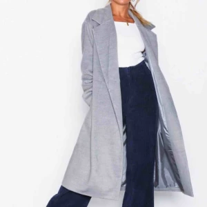  - Lång ljusgrå kappa från Nelly i storlek 40. Mycket fint skick. Fraktar ej men möts gärna upp och tar endast Swish.