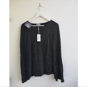  - Oanvänd, glittrig tröja med trumpetärm från Nelly 🌺