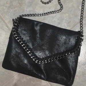 Väska  - Svart väska med silverkedja. Fraktar. Köparen står för frakten. 