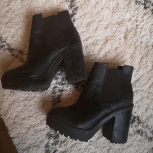 Höga boots, 35 - Höga boots med 10 cm klack och 3 cm platåsula fram. Använda men i gott väldigt gott skick! Passar även en liten 36a :) 