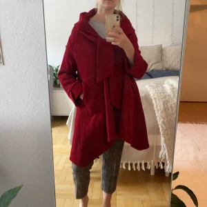 Supersöt röd kappa  - Röd kappa, värnade och fin! Tjock krage, tre knappar, fickor, knutans över bröstet och lite kortare ärmar. Kan mötas eller så står köpare för frakten. 