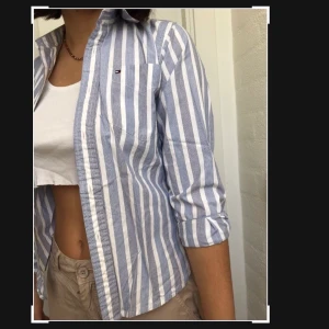 Tommy skjorta - Snygg stilren Tommy Hilfiger skjorta! Sitter ganska tajt då det egentligen är en barnskjorta men jag har använt den öppen och med uppkavlade ärmar och tycker det blir supersnyggt!
