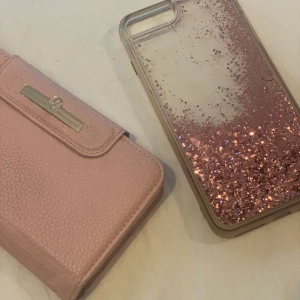  iPhone 7/8 plus skal - Säljer nu två iPhone 7/8 plus skal.                  Marvelle plånbokskal: 150kr köpt för 300kr från Fixiphone.                                                                Rosa glitter skal: 100kr köpt för 200kr från Dubai.          