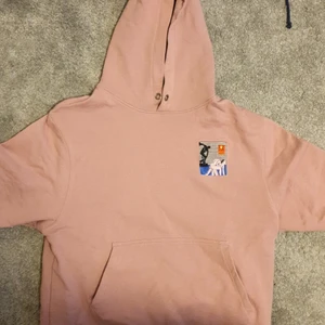 Pastell rosa hoodie, strl medium - En pastell rosa hoodie med ett spännade tryck. Köpt i början på 2020 från caliroots. Nästan aldrig använd! Betala med swish, köpare står för frakt.