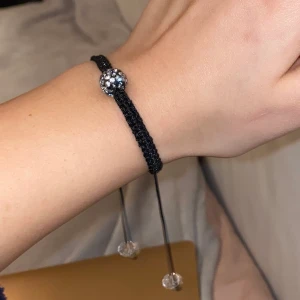 Armband  - Ett jättefint broderat armband med en Sten i mitten och två stenar där man justerar storleken. Aldrig använt 