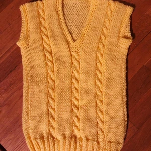Gul stickad väst  - Tillverkas för dig i Stockholm! Detta är en handgjord väst och är i storlek M. Om man vill ha den lite oversized rekommenderar vi att någon som är en S använder den. Om man vill ha den tightare funkar M. Vi tar även beställningar om din storlek inte finns.