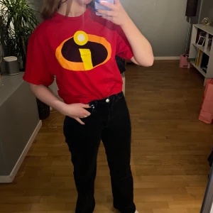 Superhjältarna tshirt  - Röd tshirt med Disneys Superhjältarna loggan på. Supersöt simplare outfit att ha till halloween eller temafester.