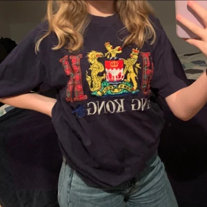 Vintage 90’s tröja med tryck! - Intressekoll! Skriv om ni skulle vara intresserade av min mammas tröja som hon köpte på 90-talet i Hong Kong🥰T-shirten är mörkblå med broderat i väldigt bra skick, inte noppror eller några fel. Passar allt mellan XS-M! Köparen står för frakten. Buda gärna!💛 (tvättas och stryks innan den skickas) Säljer en liknande i rött, in o kika profilen!