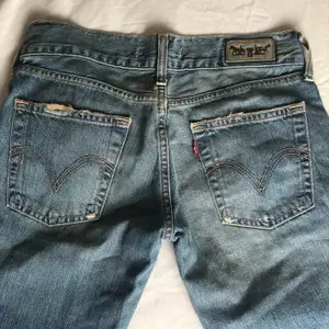 Lågmidjade vintage jeans från Levi’s med röda streck. Rak modell/ lite vidare under låret