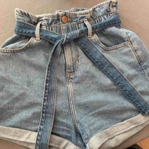  - Ljusblå jeansshorts med paperbag waist från River Island Storlek 10  