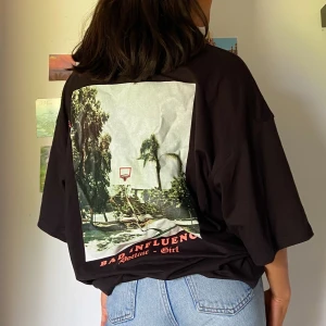 Oversized t-shirt med tryck på ryggen - Svart oversized t-shirt storlek 38 med stort tryck på ryggen. Jag har oftast storlek 34/36 och kan använda denna som klänning. Använd 1 gång och i fint skick. Högsta bud vinner och köparen står för frakt💗💗💗💗