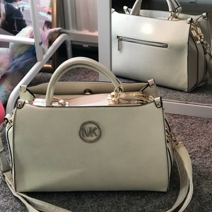 Michael kors väska  - Vit Michael kors väska med guldiga detaljer. Aldrig använd❤️orginal pris 3000, att byta går också bra, frakten är inräknad i priset 