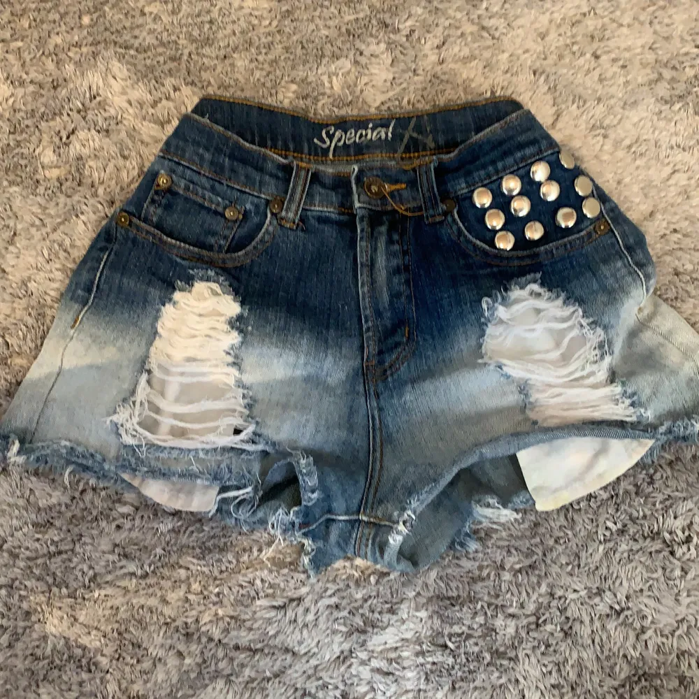 Denim shorts with metal details on front pocket and a cros on the back pocket. They are ripped in from and have very large pockets. Shorts.