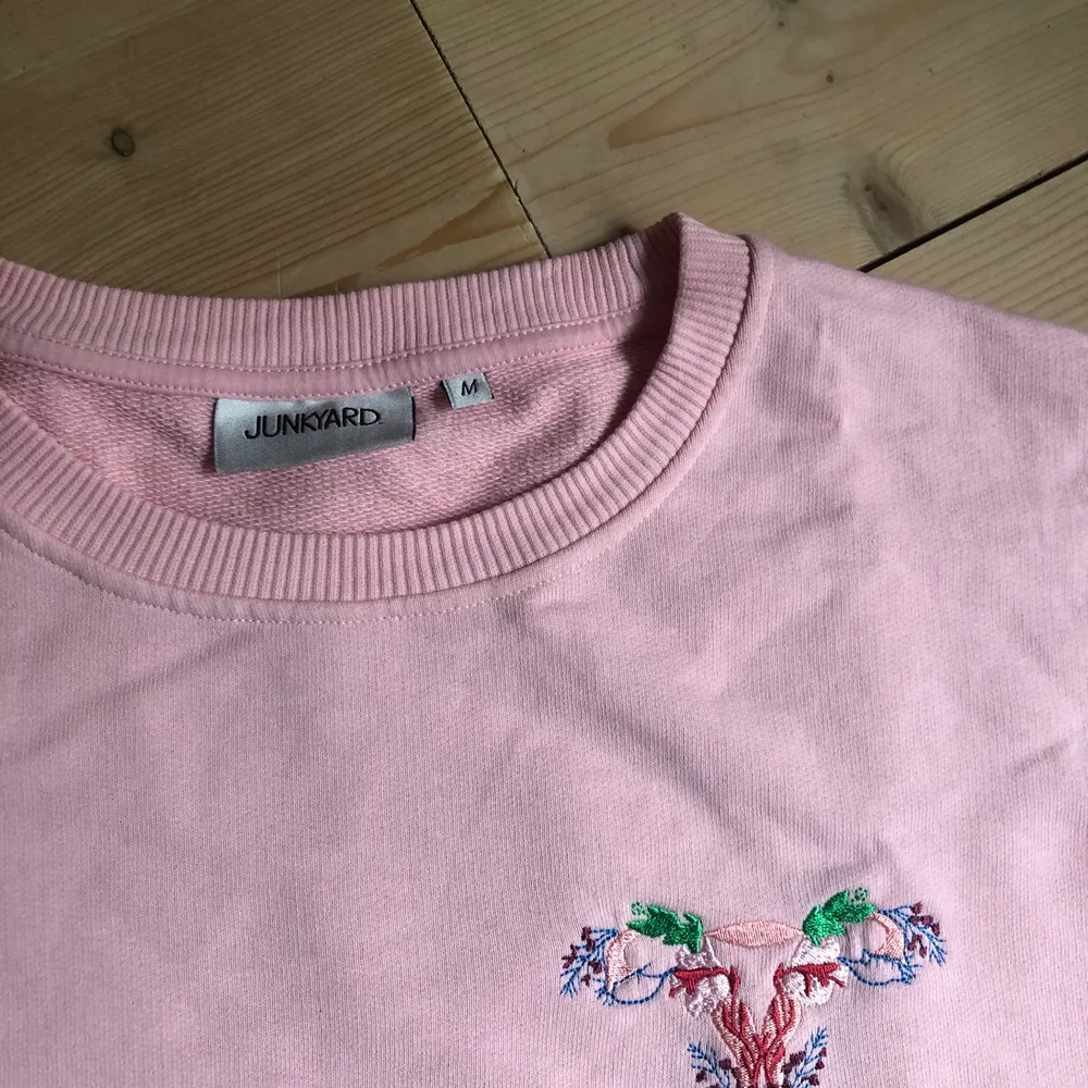Den andra bilden visar mer den rätta färgen. En rosa tröja med en föreställande livmoder i blommoga färger. Helt oanvänd. (Köparen står för frakt). Tröjor & Koftor.