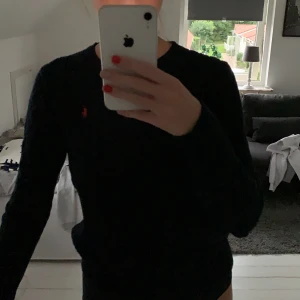 Ralph Lauren kabelstickad tröja strl S - Kabelstickad marinblå polo Ralph Lauren tröja med rött märke. Aldrig använd, strl S passar folk mellan 165-175 (passar utmärkt på mig och jag är 175cm). Hör gärna av dig vid intresse, pris kan diskuteras!