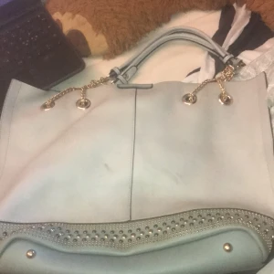 Blå väska - Den har en liten fläck  som man ser på bild 1 men jag tror det går att få bort köparen står för frakt:)