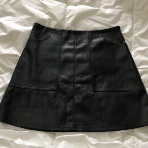 Skinnkjol från bikbok - En fin kjol i skinnmaterial köpt på bilbolaget. Fickor framtill