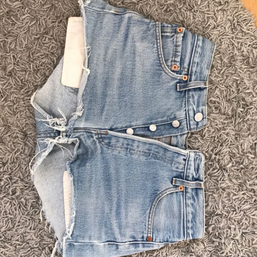 Säljer mina fina jeansshorts från Levis pga att de börjar bli för små för mig.. står storlek 29 på lappen men skulle säga att de är i storlek XS då de är rätt korta. Den enligt mig perfekta tvätten och inte ett dugg slitna! Köparen står för eventuell frakt. . Shorts.