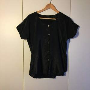 True vintage black satin shirt with natural buttons. Interesting shape arms and flattering cut. 