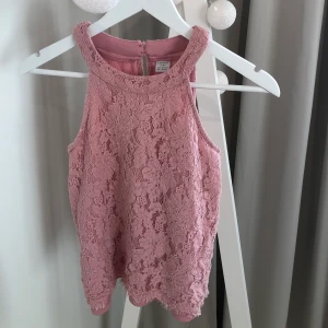 Rosa halterneck top - Superfin rosa halterneck top i spets från Lindex. Väldigt bra skick! Storlek 158/164 men passar även xs och s. Frakten ingår i priset!!