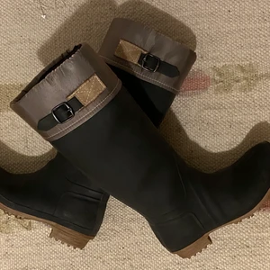 Stövlar - Säljer dessa superfina svarta stövlar i strl 37 då dem har inte kommit till användning. (Använt endast 2 gånger) . Dem har en begie rem upptill och det är en reflex.