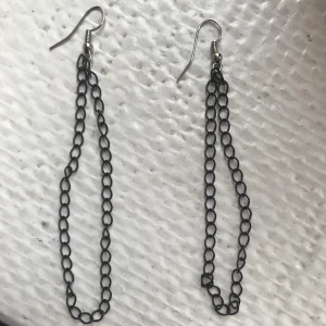 Örhängen med svart kedja  - Örhängen med en svart kedja som bildar en ögla. Säljes då jag inte använder dessa längre 😊 pris kan diskuteras 