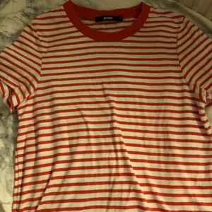 Vit och rödrandig t-shirt - Vit och rödrandig t-shirt i strl XS. Skriv om du vill ha bättre bilder på plagget, tex passform på kroppen osv!