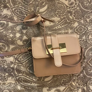 Pastell rosa väska från Åhléns. - Pastelle rosa väska från Åhléns som tyvärr inte kommer till användning för mig. Små synliga tecken på användning men dock bara på insidan (syns på bild Nr 2). Köparen bestämmer ett lämpligt pris! Kan mötas upp och frakta!