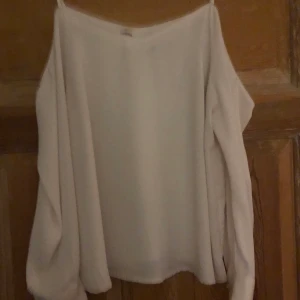 Blus - Beige blus med öppna axlar och långärmad. Köparen står för frakten och det angivna fraktpriset kan ändras!! 